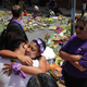 People embrace at the spot where Heather Heyer was killed and 19 others injured when a car slammed into a crowd of people protesting against a white supremacist rally, August 16, 2017 in Charlottesville, Virginia. Charlottesville will held a memorial service for Heyer Wednesday, four days after she was killed when a participant in a white nationalist, neo-Nazi rally allegedly drove his car into the crowd of people demonstrating against the ‘alt-right’ gathering.